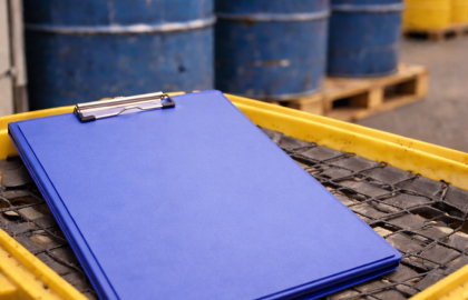 Carpeta cerrada sobre pallet de contención frente a contenedores industriales