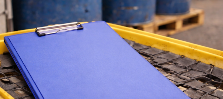 Carpeta cerrada sobre pallet de contención frente a contenedores industriales