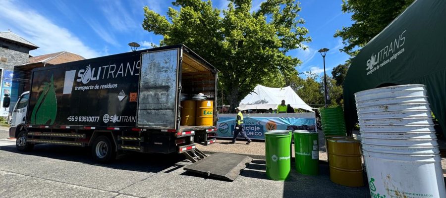 Camión de Solitrans realizando operación de recolección de residuos en una campaña de reciclaje al aire libre, con tambores industriales y personal trabajando.